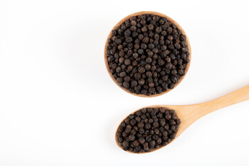 Black pepper grains in a bowl on a white background