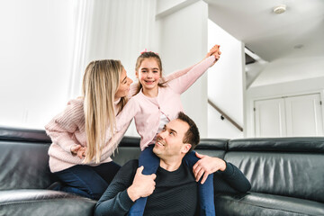 Dad and mother with his cute little girl on a modern house