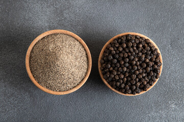 Ground black pepper with grains of black pepper on a black background,top view
