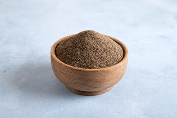 Powder black pepper on bright background, top view
