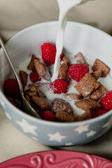 breakfast, cereal with milk, coffee with milk in a faceted glass, beterbrots with chocolate butter, berries and bananas