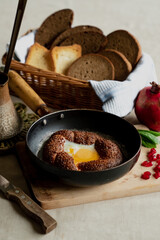 Turkish breakfast, scrambled eggs in a simit bun in a frying pan, coffee in a Turk, fresh bread
