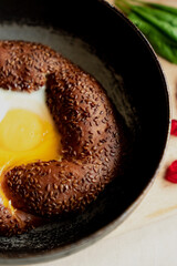 Turkish breakfast, scrambled eggs in a simit bun in a frying pan, coffee in a Turk, fresh bread