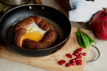 Turkish breakfast, scrambled eggs in a simit bun in a frying pan, coffee in a Turk, fresh bread