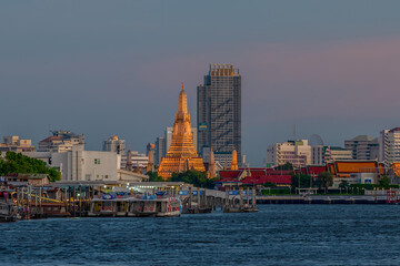 Obraz premium Wat Arun Ratchawararam or Temple of Dawn and five pagodas during twilight.