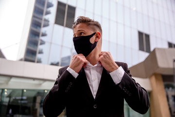 Young businessman in a business center, straightens collar close-up portrait