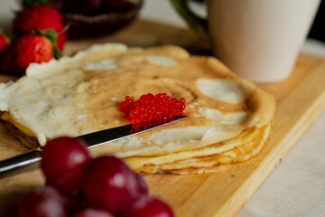Pancake with red caviar for breakfast, a cup of tea