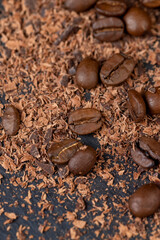 Roasted coffee beans lie together with chocolate crumbled into small pieces
