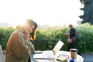 Charming freelancer in sunny garden working remotely