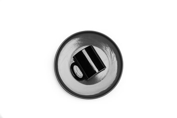 Plato redondo junto a una taza sobre un fondo blanco liso y aislado. Vista superior y de cerca. Copy space