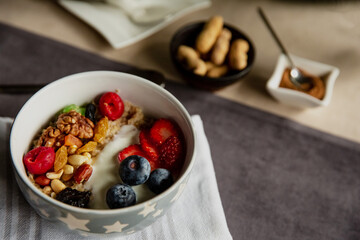 Black tea with rose flowers in a glass transparent teapot with a cup, beautiful breakfast