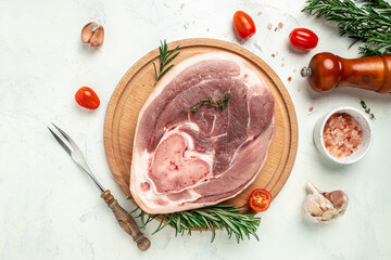 Raw pork ham cut on a wooden board. Leg meat on a light background, Culinary cooking. banner, menu,...