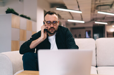 Serious businessman talking on smartphone in office