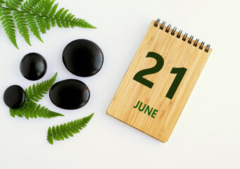 June 21. 21th day of the month, calendar date. Notepad, black SPA stoneJune s, green leaves. Summer month, day of the year concep