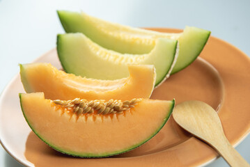 Honeydew melon and Japanese melon slice fresh ripe orange and sweet green slice lay on leaf in plant. Melon or cantaloupe is sweet fruit dessert.