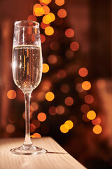 Close-up of one glass of champagne on a dark background with blurred hearts. The concept of Valentine's Day. Overlay for your design with space to copy. High quality photo