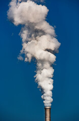 industrial smoke from chimney on blue sky
