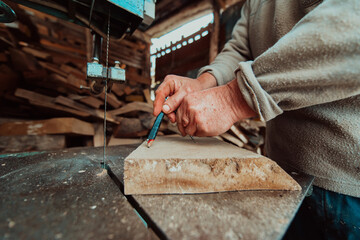 Closeup photo of a senior man outlining wood and preparing it for processing
