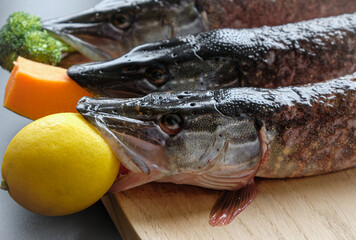 Three raw pikes and vegetables.