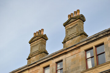 Fototapeta na wymiar Close Up of Classical Style Chimney Stacks on Stone Tenement Building 