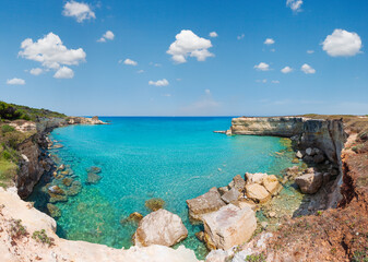 Picturesque seascape with white rocky cliffs, sea bay, islets and faraglioni at beach Spiaggia...