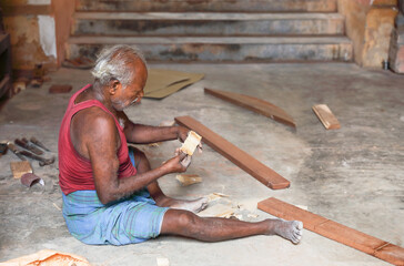 Indian Carpenter working on wood by using traditional tools