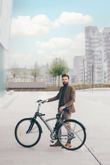 Plakat Contemporary bearded young stylish businessman going to work by bike commuting the carbon-free way