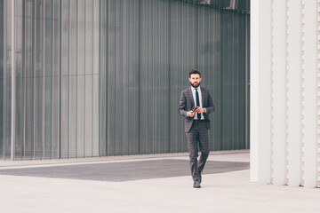 Confident and professional elegant bearded businessman walking outdoor strong and trusty