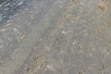 Details of a road polluted with sand and debris from fields