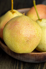 Ripe yellow pear with red shades covered with drops of pure water