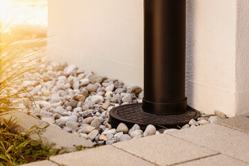 French Drain Stone Pebble and Waterspout. Downspout with Drainage Floor Gravel outside House - obrazy, fototapety, plakaty