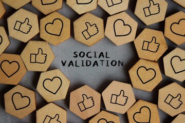 Text SOCIAL VALIDATION surrounded by wooden cubes with thumbs up and heart icon. Social validation...