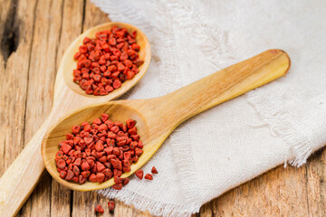 Achiote grains in container, typical condiment of South America, close-up image
