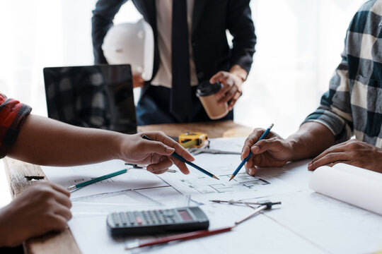 Consulting architect and engineer to discuss work, pointing to house plans to make changes to make things better and easier to work with.