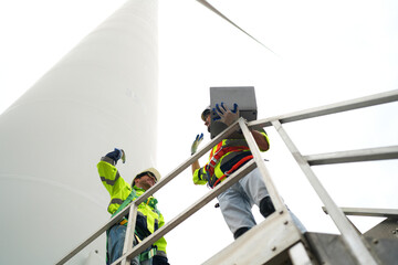 engineer with laptop at wind turbine site.