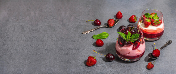 Delicious Italian dessert panna cotta with sweet cherry sauce, fresh strawberries and mint leaves