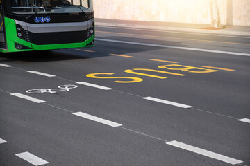 The bus travels along the road with markings.