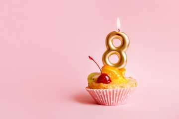 Golden candle with number eight on a cake on pink background 8 march greeting card