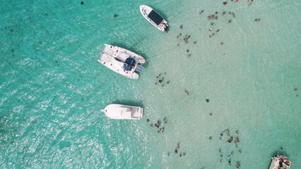 Aerial view of tourists swimming yachts and tour boats in sting ray city in Cayman Islands in shallow turquoise water