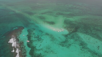 Super high aerial view of yachts and tour boats in sting ray city in Cayman Islands in shallow turquoise water