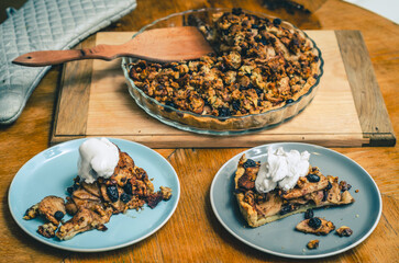 A piece of sweet cake with nuts, apples on a blue plate