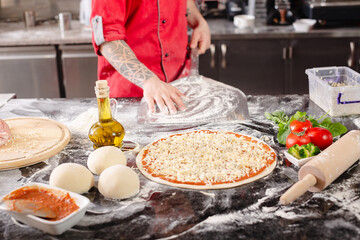 pizzaiolo prepares pizza in the kitchen, the chef prepares the dough