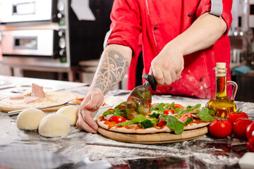pizzaiolo prepares pizza in the kitchen, the chef prepares the dough