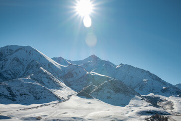 Panoramic view of snowcapped mountains illuminated by the sun. Winter. beautiful clear blue sky in daylight. impressive view of the mountain peaks