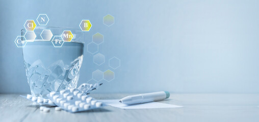 a glass of water, tablets, a pen.icons with microelement symbols. Supplements. health concept. banner. Copy space