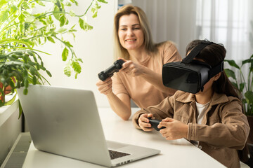 family, technology and virtual reality concept - mother and daughter in vr glasses playing at home.