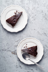 Slices of chocolate cake with walnuts, vegan dessert on gray background