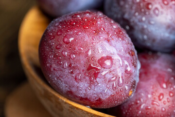 Ripe plums of dark color on the table
