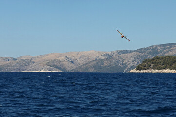 Fototapeta na wymiar Fire fighting airplane in action, Hvar Island, Croatia