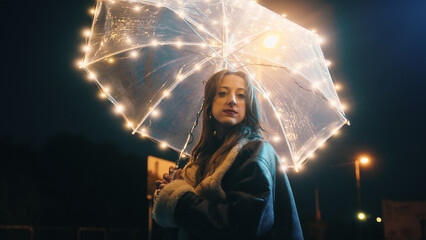 Romantic girl with transparent umbrella in the night